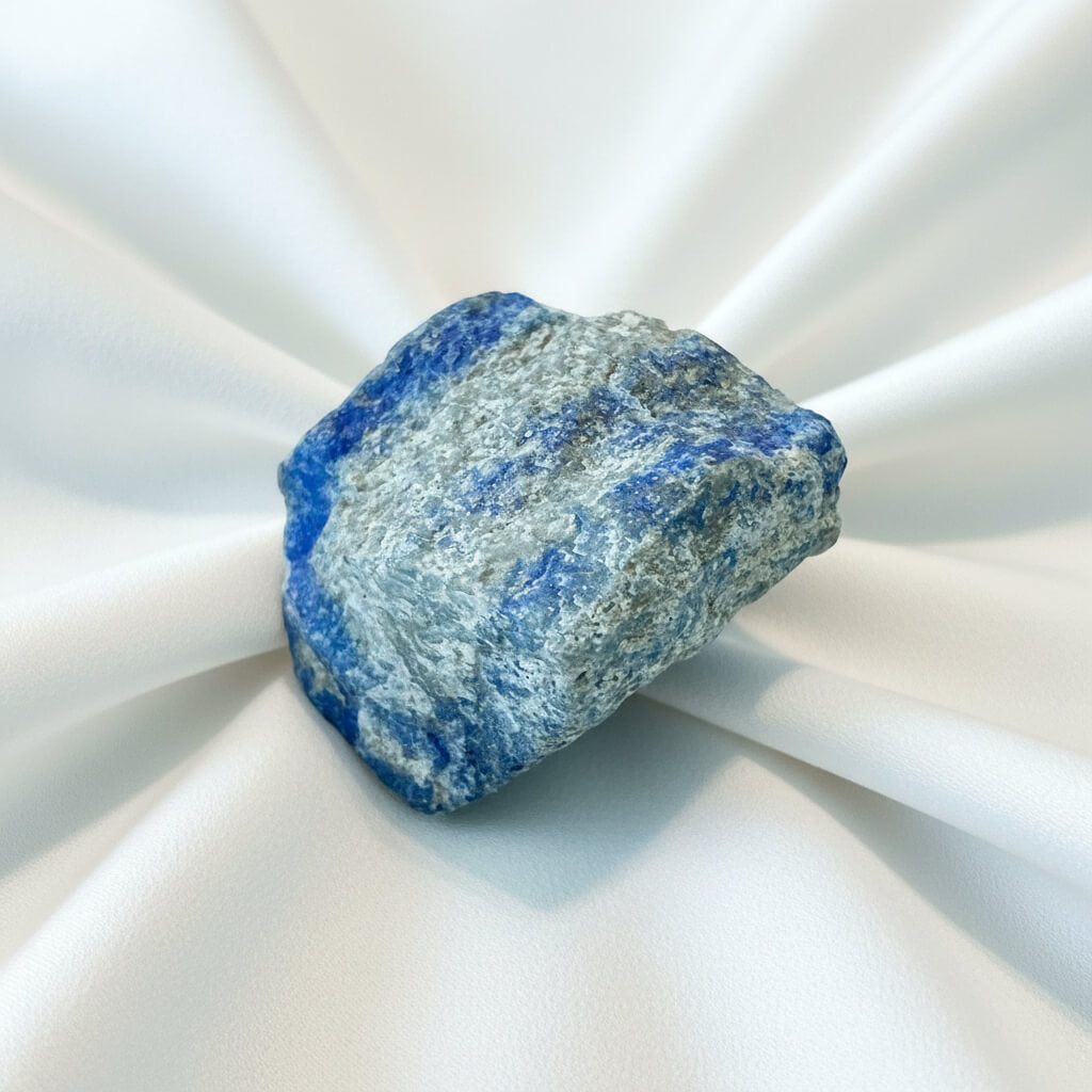 close up of raw natural lapis lazuli crystal streaks of royal blue with silver 