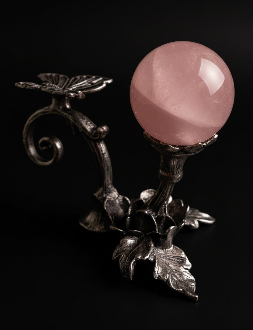 photo close up of rose quartz sphere in a silvery butterfly stand