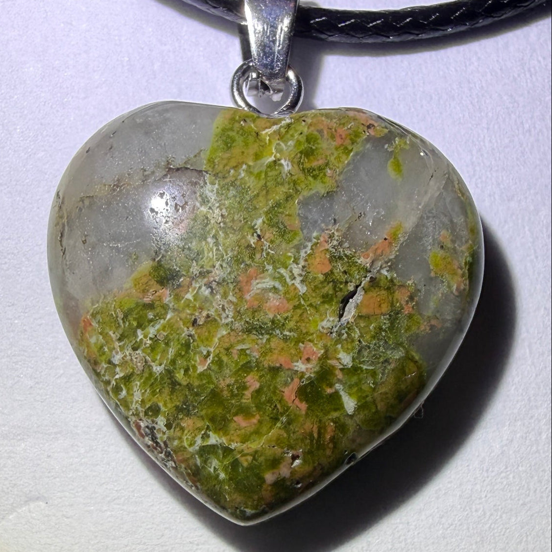 close up unakite carved heart pendant with natural fracture