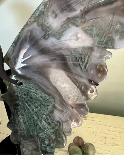 Close-up of a carved butterfly wing made of moss agate.