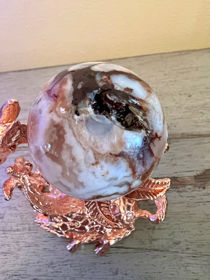 Agate sphere on rose gold stand.
