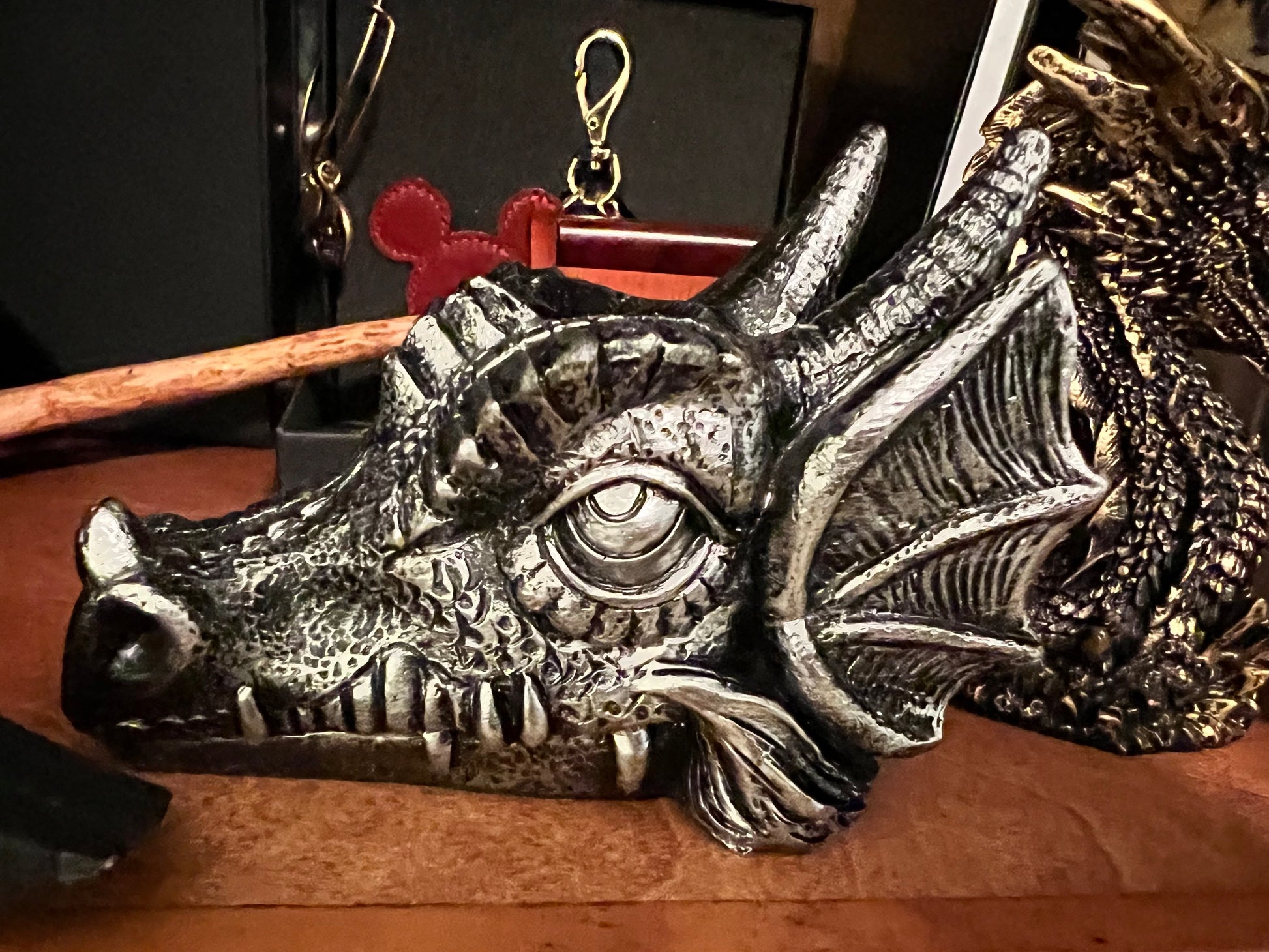 Silver dragon head with sharp teeth and detailed scales.
