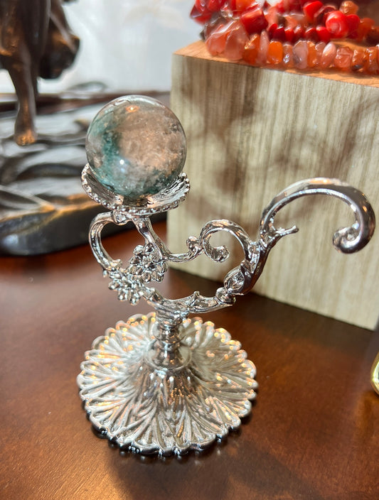 A silver stand holding a crystal ball.