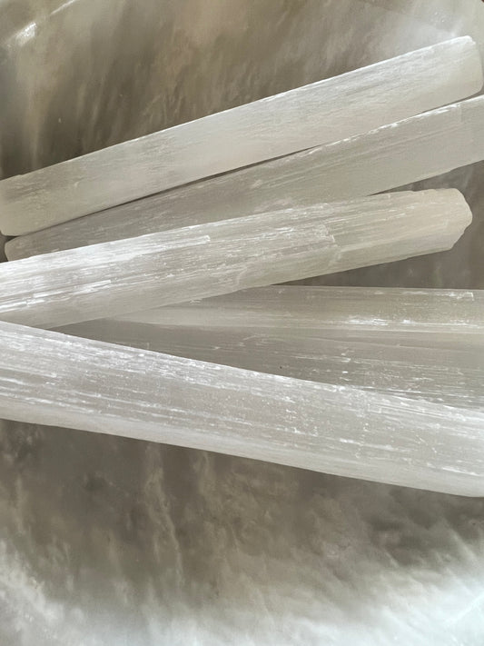A close-up of a group of translucent selenite sticks.