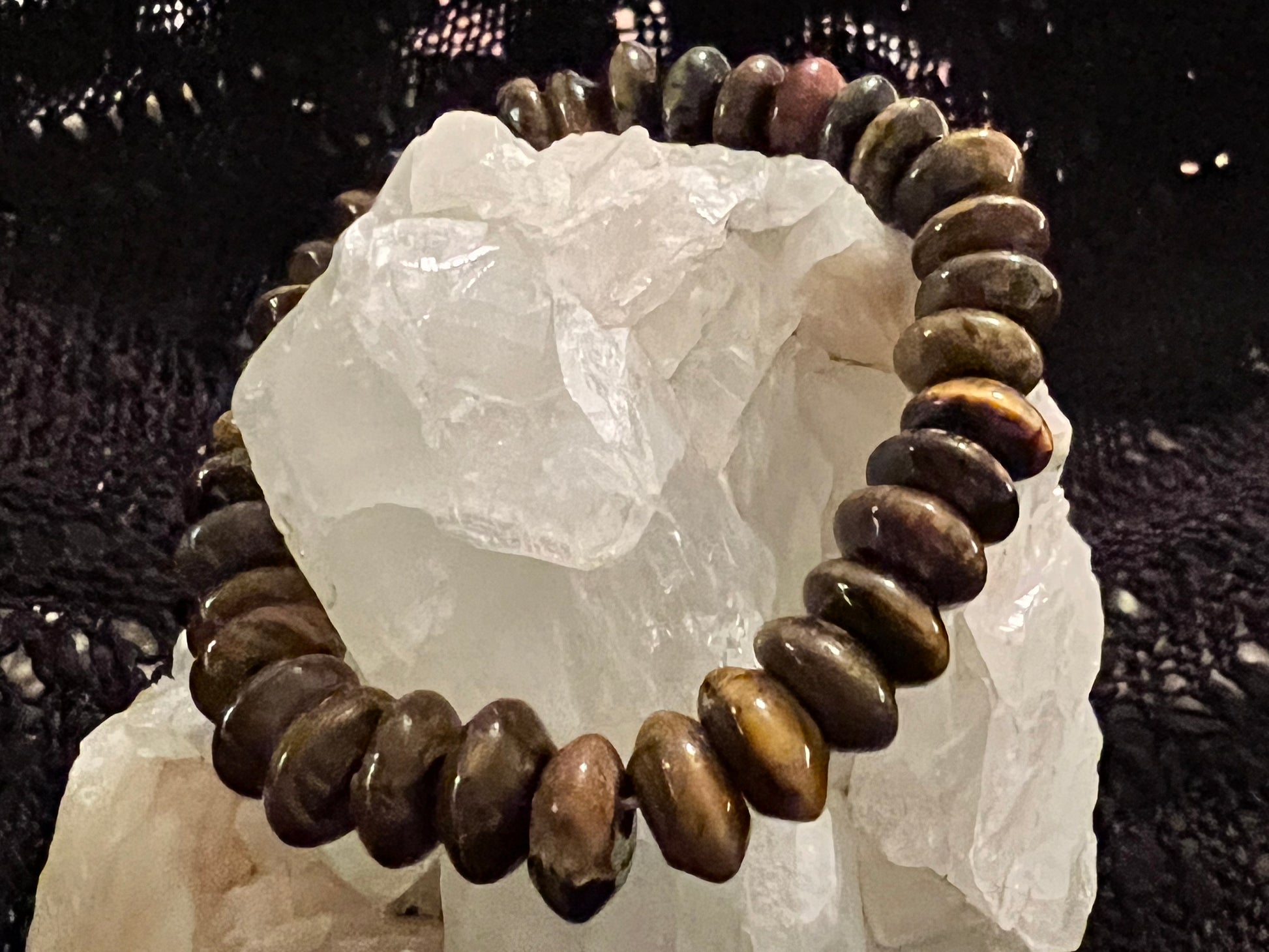 Brown beaded bracelet on a white crystal. 
