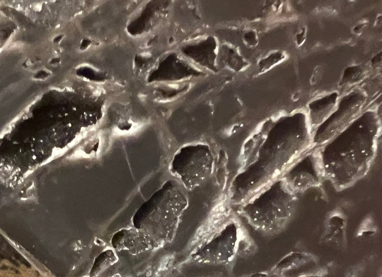 Close-up of a gray and white geode with crystal formations.