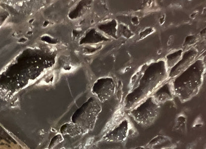 Close-up of a gray and white geode with crystal formations.