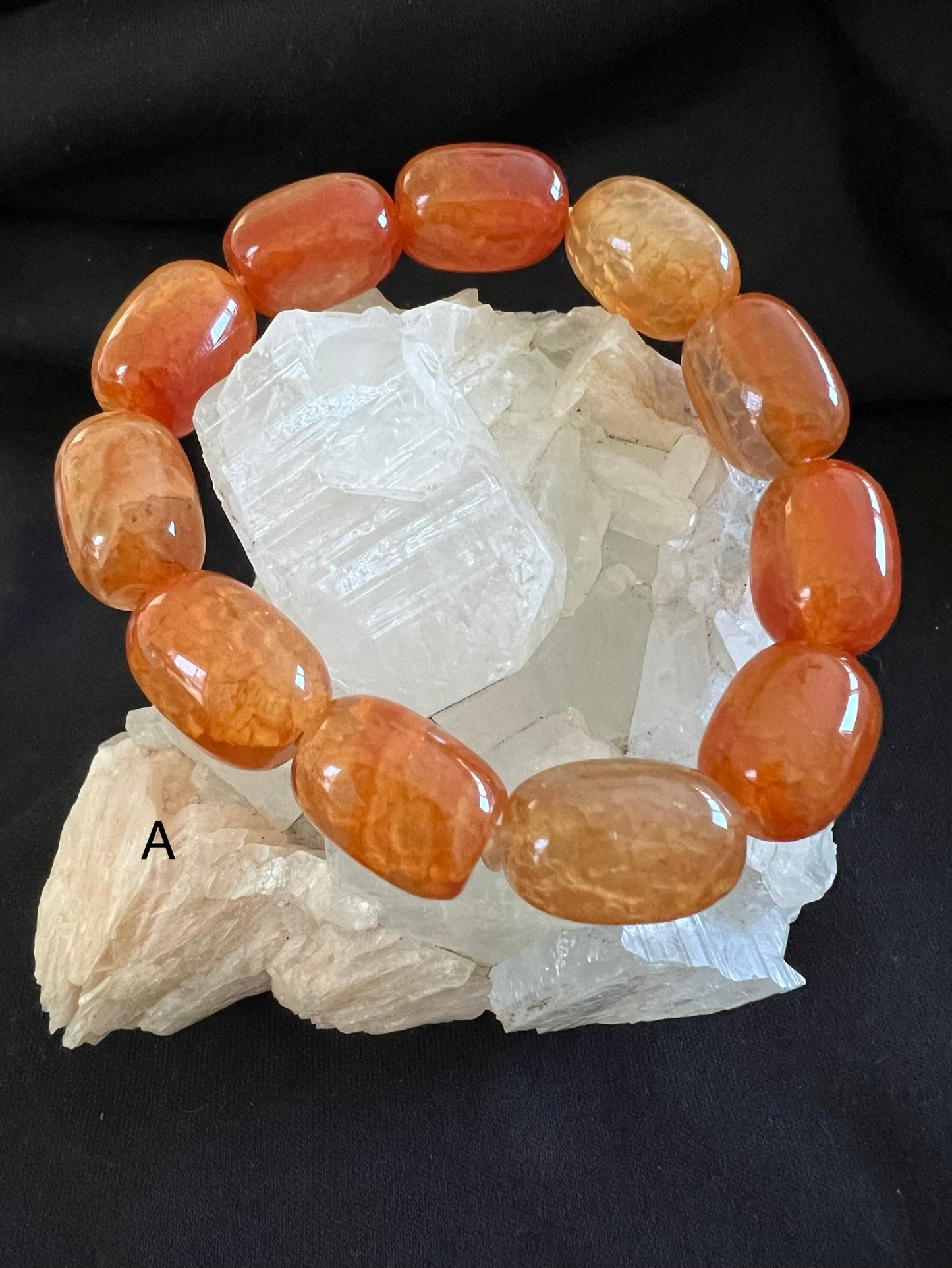 Orange carnelian bracelet on white quartz crystal.