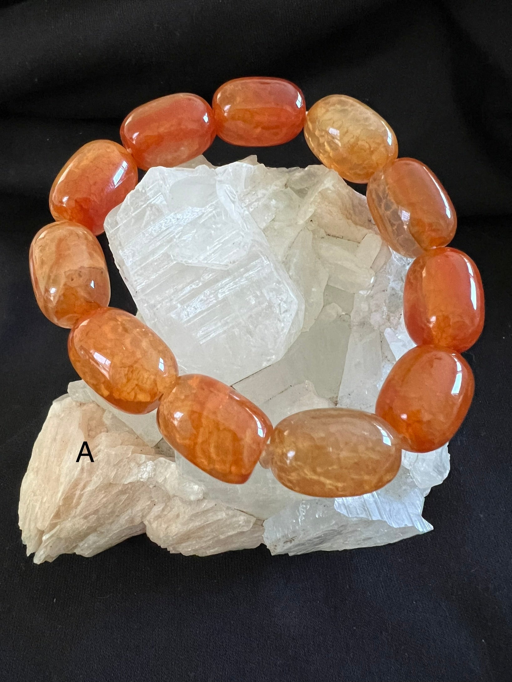 Orange carnelian bracelet on white quartz crystal.