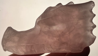 Translucent pink rose quartz dragon skull carving.