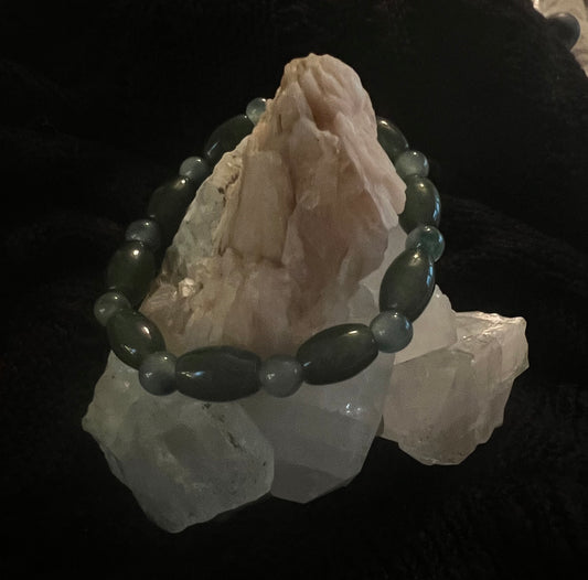 A beaded bracelet is draped over several white crystals.